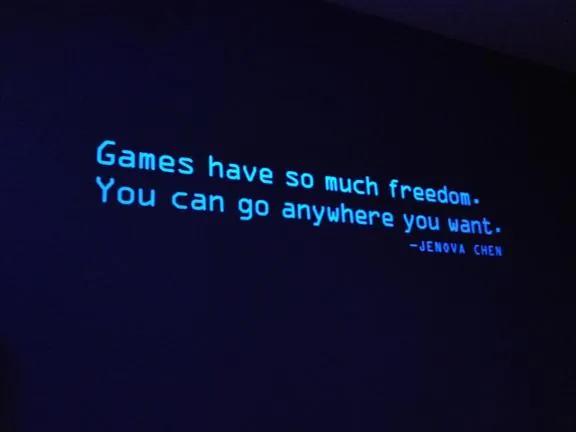 Wall text reading "Games have so much freedom. You can go anywhere you want." credited to Jenova Chen