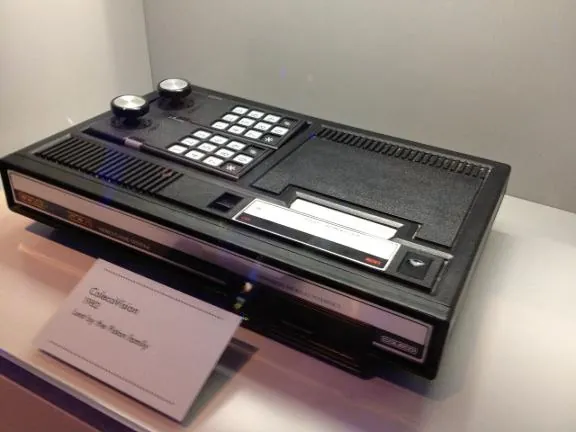 A ColecoVision console with its keypad controllers in a museum case