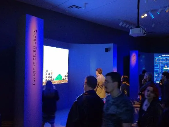Visitors outside the Super Mario Brothers room, with the Pac-Man room visible beyond